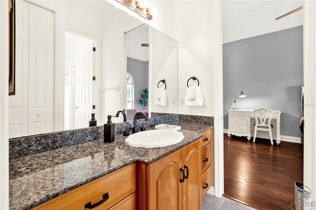 bathroom featuring vanity, baseboards, and wood finished floors