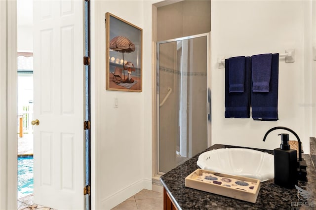 bathroom with baseboards, a stall shower, tile patterned floors, and vanity