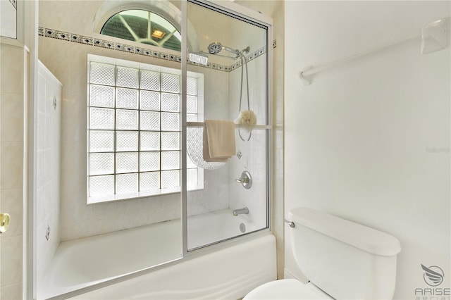 bathroom featuring shower / bath combination with glass door and toilet