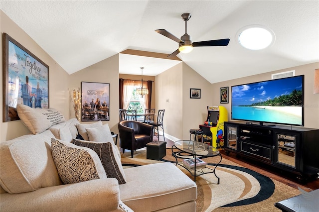 living room with ceiling fan with notable chandelier, visible vents, wood finished floors, and lofted ceiling