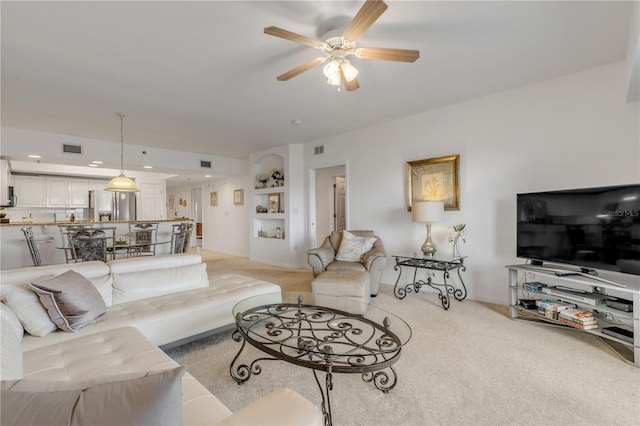 living room with light colored carpet and ceiling fan