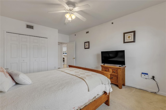 carpeted bedroom with ceiling fan and a closet