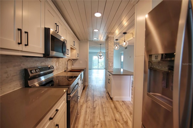 kitchen featuring light wood-type flooring, sink, appliances with stainless steel finishes, and white cabinetry