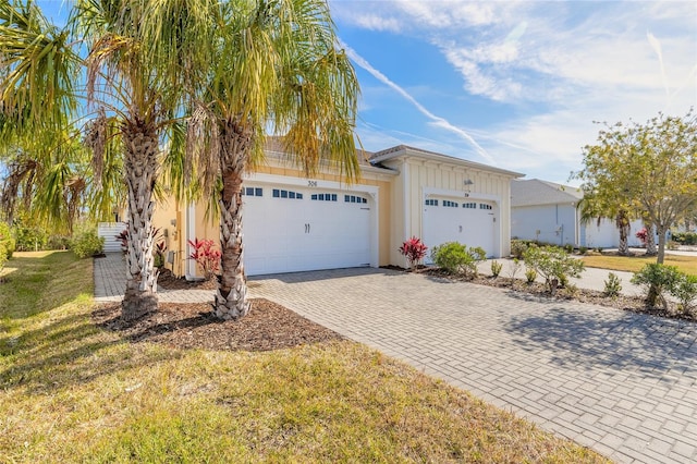 ranch-style house with a garage and a front lawn