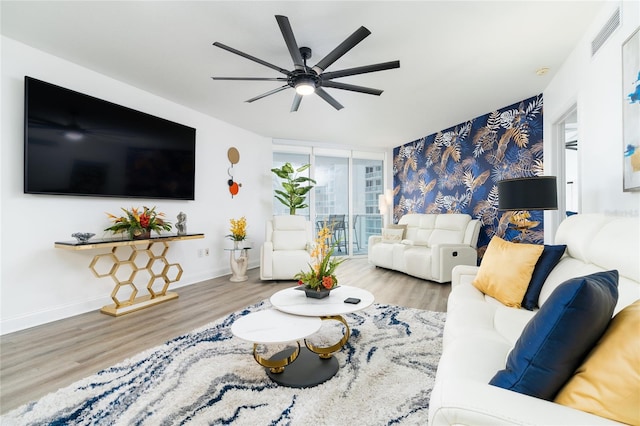 living room featuring floor to ceiling windows, ceiling fan, and light hardwood / wood-style flooring