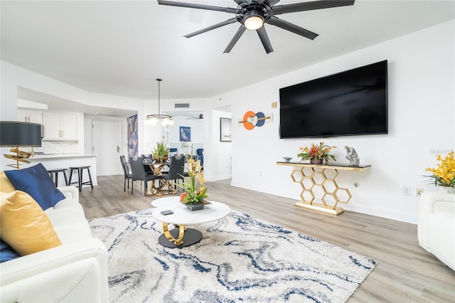 living room with ceiling fan and light wood-type flooring