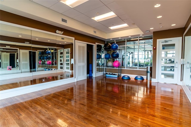 workout area featuring hardwood / wood-style flooring and a drop ceiling