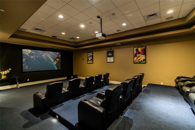 carpeted cinema room with a tray ceiling