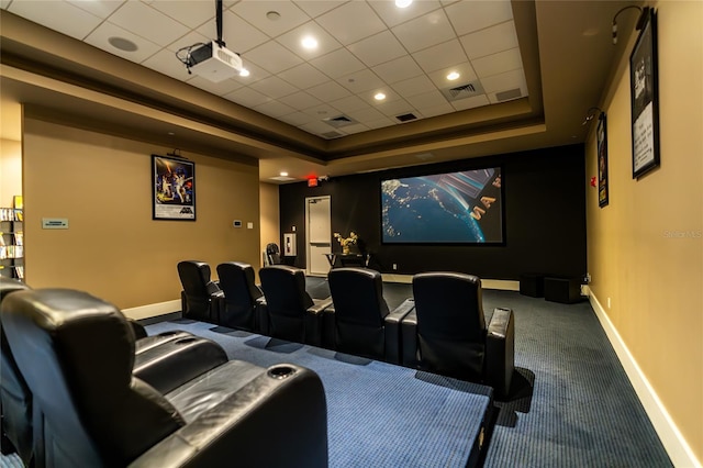 carpeted home theater room featuring a raised ceiling and a paneled ceiling