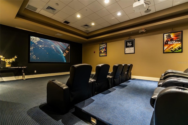 home theater featuring a tray ceiling and carpet flooring