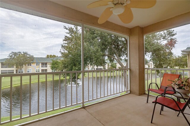 sunroom with a water view and ceiling fan