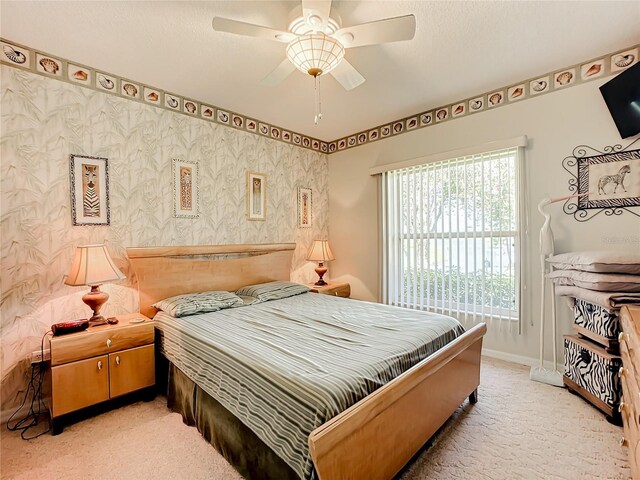 carpeted bedroom with a textured ceiling and ceiling fan