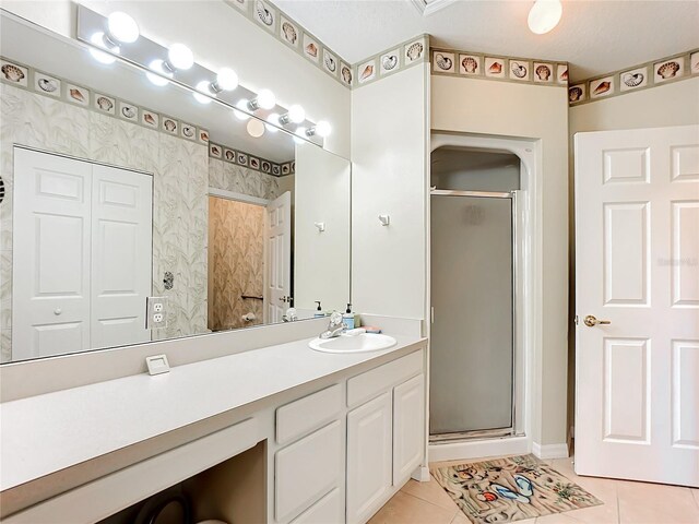 bathroom featuring vanity, an enclosed shower, and tile patterned floors