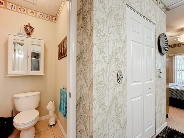 bathroom with toilet, tile patterned floors, and a textured ceiling