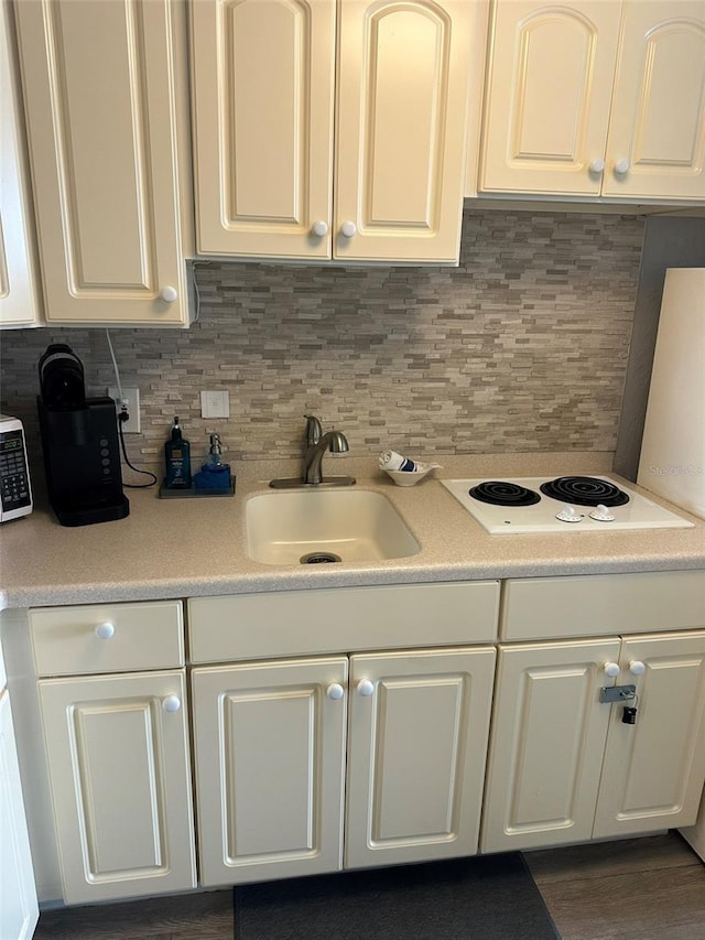 2700 N Atlantic Ave Unit 423, Daytona Beach, FL 32118 - kitchen with white cabinets, light countertops, white electric cooktop, and decorative backsplash