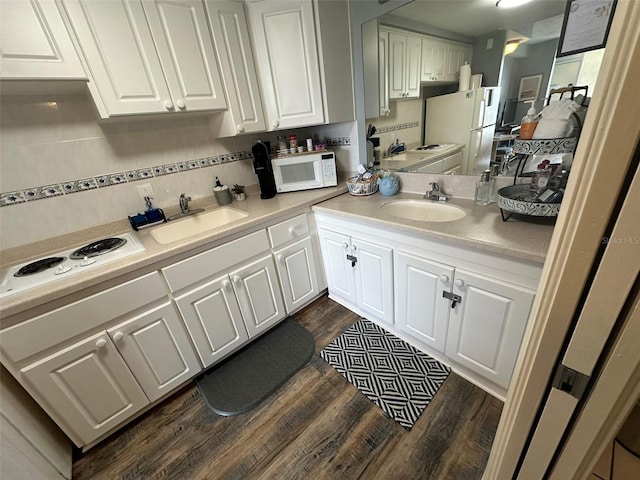 kitchen with dark hardwood / wood-style floors, white appliances, white cabinetry, and sink