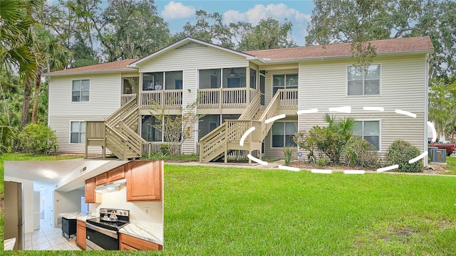 rear view of house with stairs, central AC unit, a lawn, and a sunroom