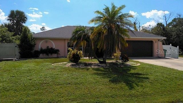 ranch-style home featuring a garage and a front lawn