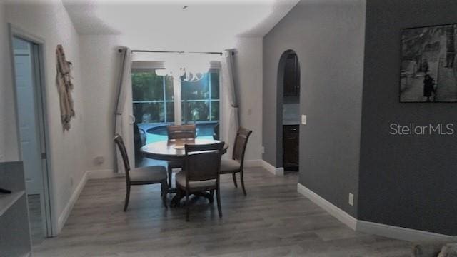 dining space featuring wood-type flooring and a notable chandelier