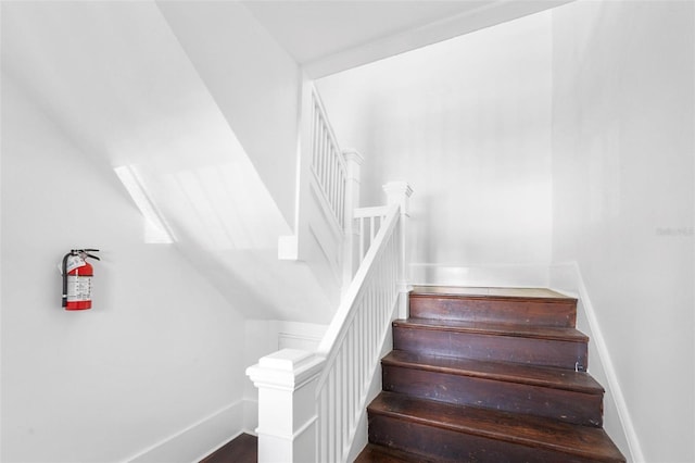 staircase featuring vaulted ceiling and hardwood / wood-style flooring