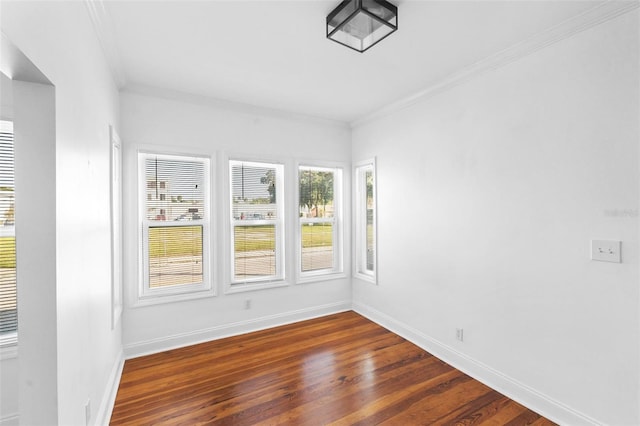 spare room featuring ornamental molding and dark hardwood / wood-style floors