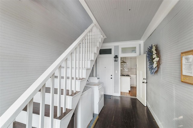 staircase with hardwood / wood-style floors and washer and dryer