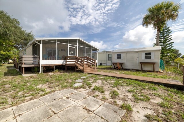 back of house featuring a deck and a sunroom