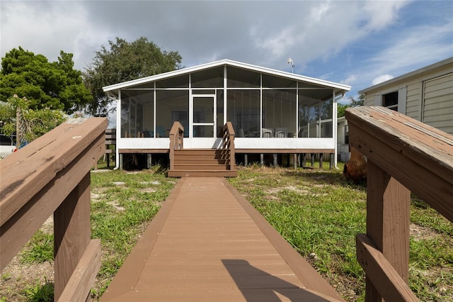 rear view of property with a sunroom and a lawn