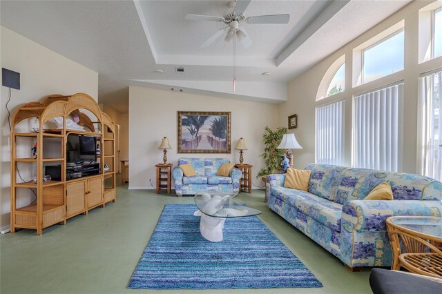 carpeted living room featuring a tray ceiling and ceiling fan