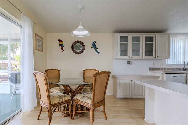 dining area featuring a textured ceiling and light hardwood / wood-style flooring