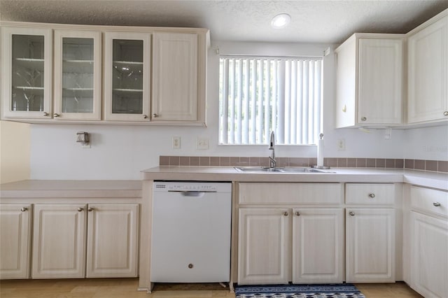 kitchen featuring dishwasher, a textured ceiling, and sink