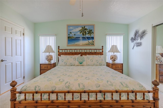 bedroom with ceiling fan, carpet floors, vaulted ceiling, and multiple windows