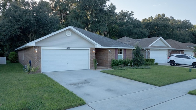 ranch-style home with cooling unit, a front yard, and a garage