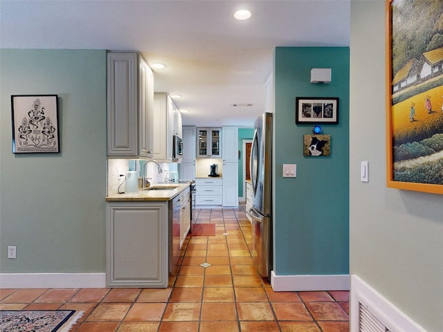 kitchen with white cabinetry, tasteful backsplash, appliances with stainless steel finishes, and sink