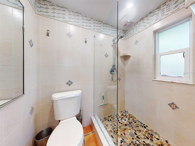 bathroom featuring tile walls, toilet, and walk in shower