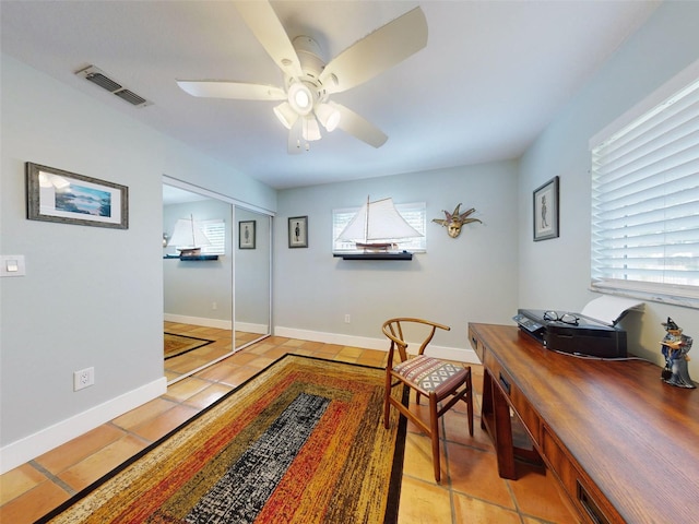 home office featuring light tile patterned floors and ceiling fan