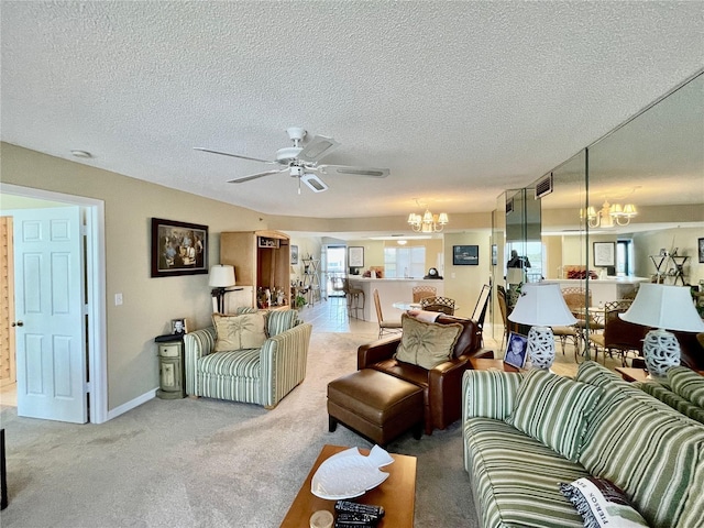 carpeted living room with a textured ceiling and ceiling fan with notable chandelier