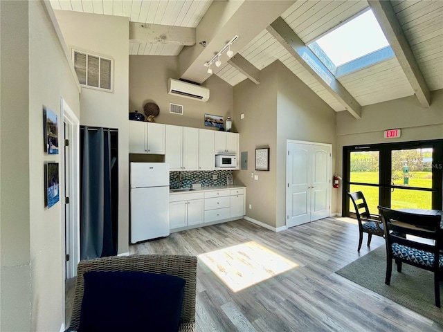 kitchen with a skylight, backsplash, white cabinets, white appliances, and a wall unit AC