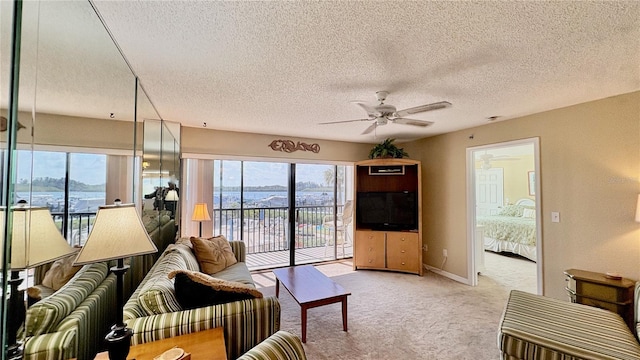 carpeted living room featuring a textured ceiling and ceiling fan