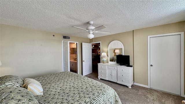 bedroom with ceiling fan, carpet floors, and a textured ceiling