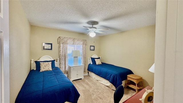 carpeted bedroom with ceiling fan and a textured ceiling