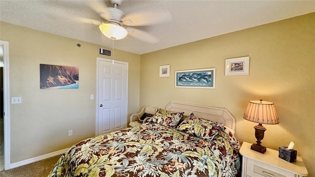 carpeted bedroom featuring ceiling fan and a textured ceiling