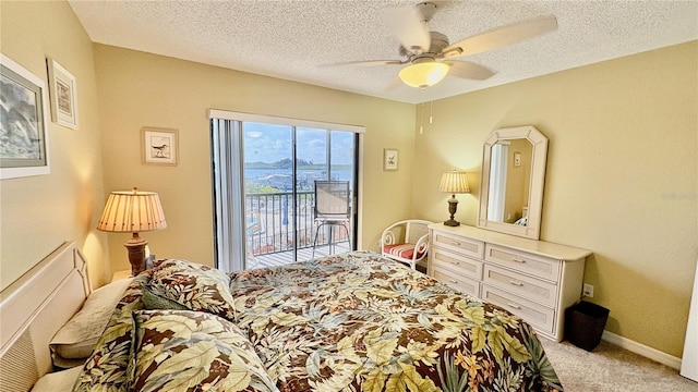 carpeted bedroom featuring access to exterior, a textured ceiling, and ceiling fan