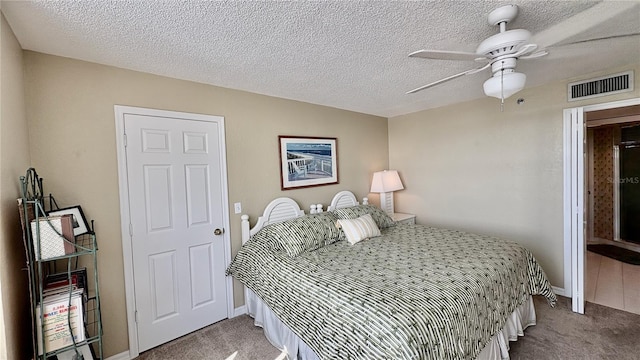 bedroom featuring ceiling fan, a textured ceiling, and carpet