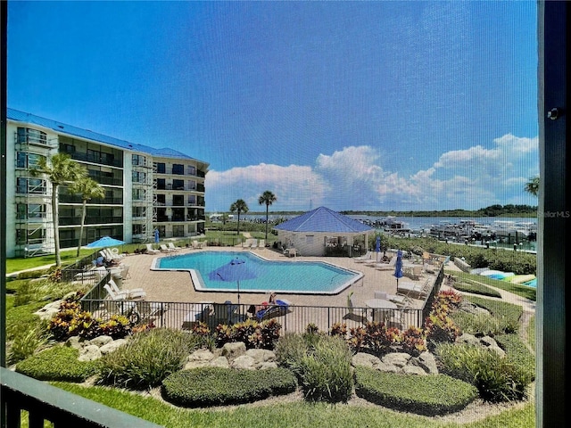 view of swimming pool with a water view and a patio area