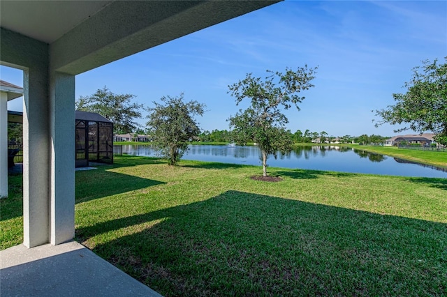 view of yard featuring glass enclosure and a water view