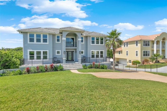 mediterranean / spanish-style house featuring a balcony and a front lawn