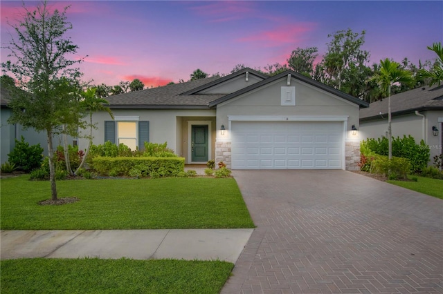 ranch-style home with a garage and a lawn