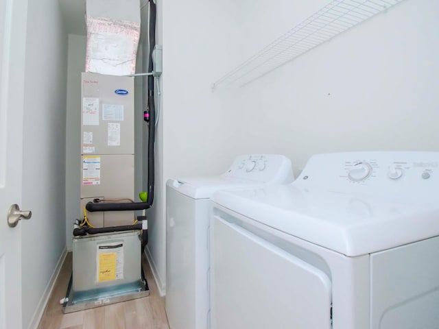 laundry area with light wood-type flooring and washer and dryer