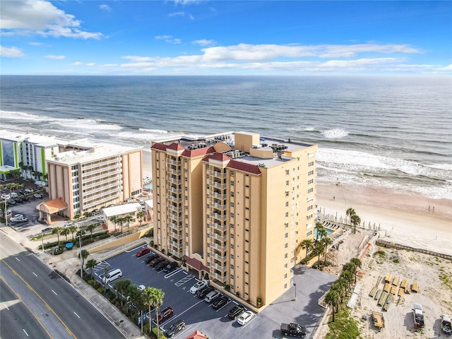 drone / aerial view featuring a water view and a view of the beach